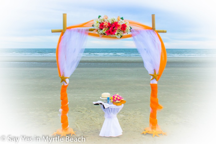 Orange and white tulle wrapped arbor